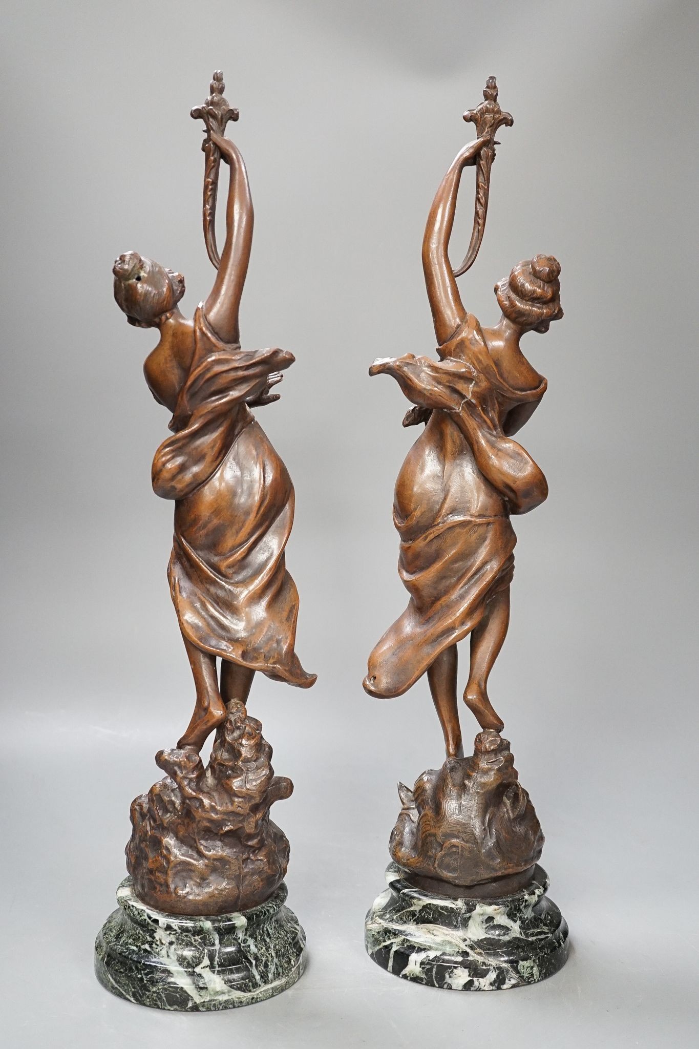 A pair of bronze female dancers, on marble plinths, 47cm